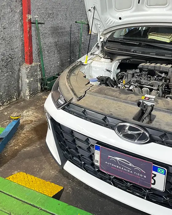 Veículo com o capô aberto no box da Automecânica Tico's